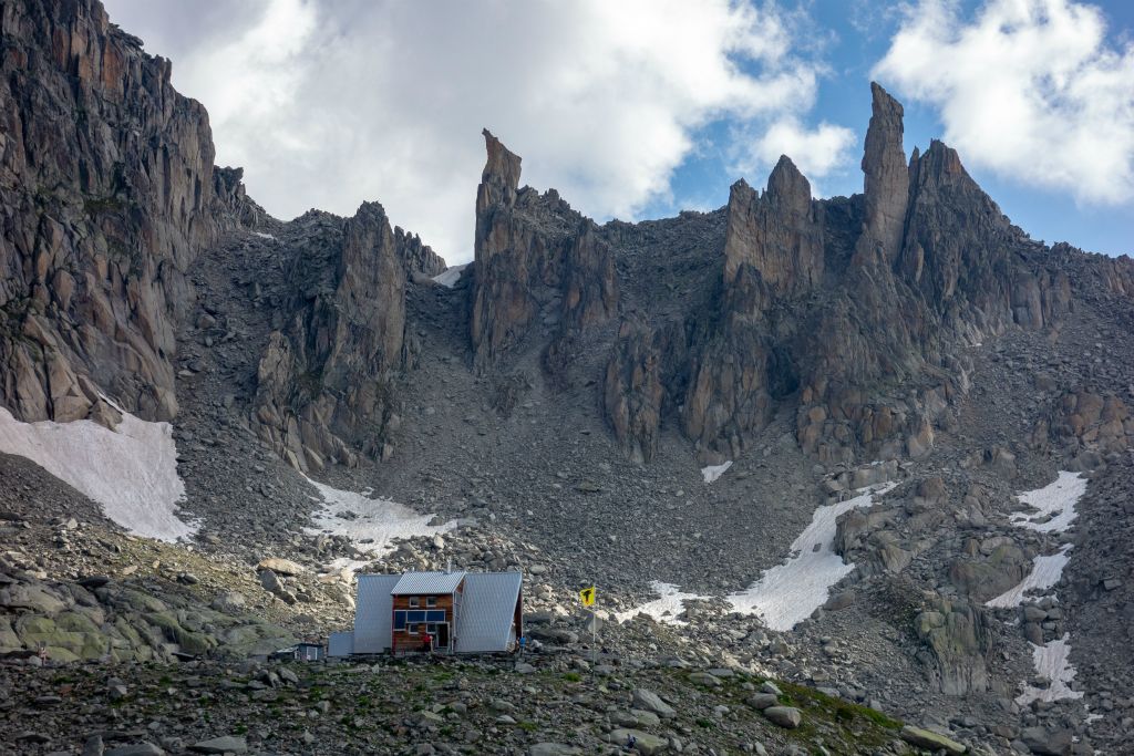 A l'arrière plan de la cabane, de très beaux sommets extrèmement découpés dont "Le Petit Chameau" que l'on peut voir sur une publicité pour Mammut