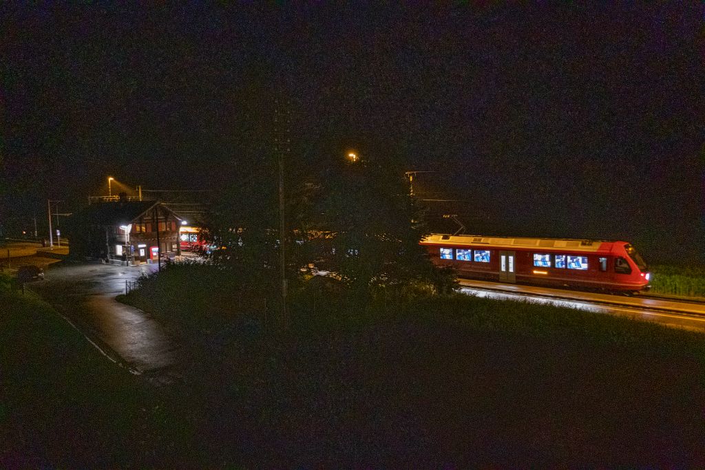 De notre camp on peut admirer, malgré la pluie et le brouillard, une petite gare et un train suississimes !